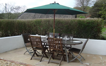 Enford House Cottage Self catering holiday cottage has a south facing terrace table which seats 6 people with a BBQ