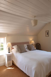 The master bedroom at Enford House cottage has views over the meadow and garden. Ensuite bathroom and facilities